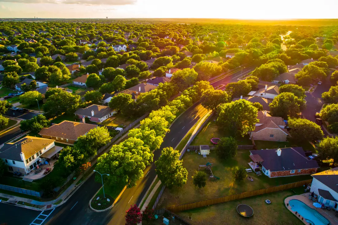 Aerial photo of a suburban neighborhood with rows of near-identical houses on tree-lined streets