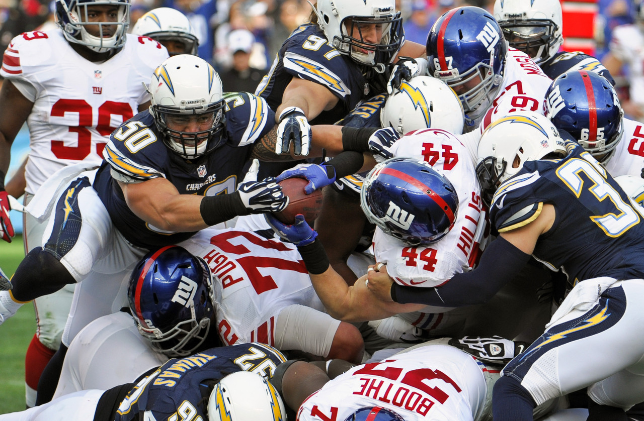 AP photo of football players piled on top of each other, standing in for miners dogpiling on a block