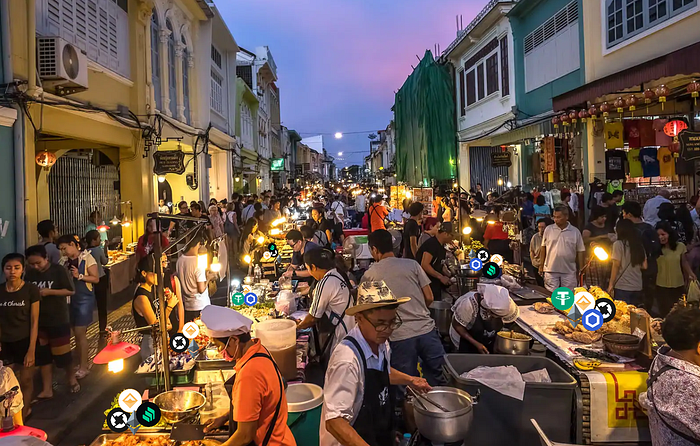 Photo of a crowded Phuket night market at dusk with crypto token logos overlaid on the food stalls
